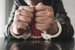 Hand-Cuffed-Man-On-Table